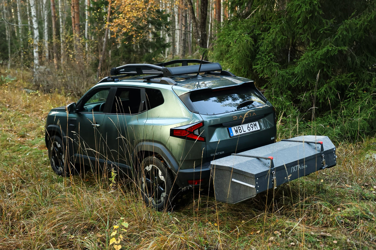 Dacia Duster équipé d'un coffre d'attelage IXTAbox, garé sur un chemin forestier